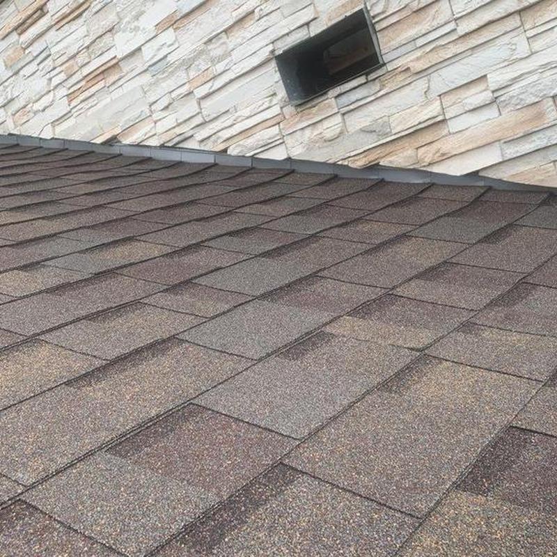Asphalt shingle roof near stone chimney and vent