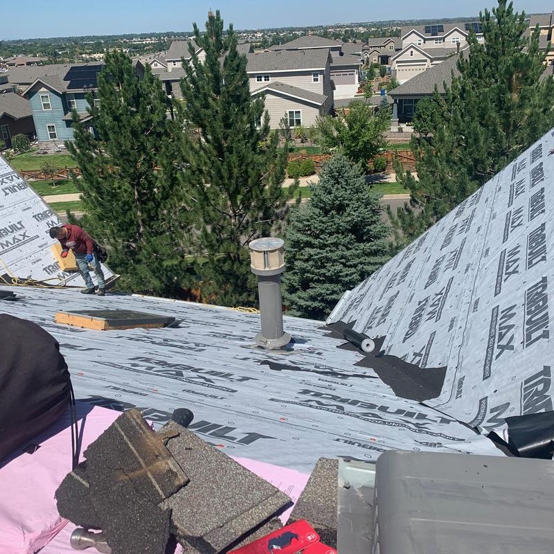 Asphalt shingle roof underlayment installation with worker