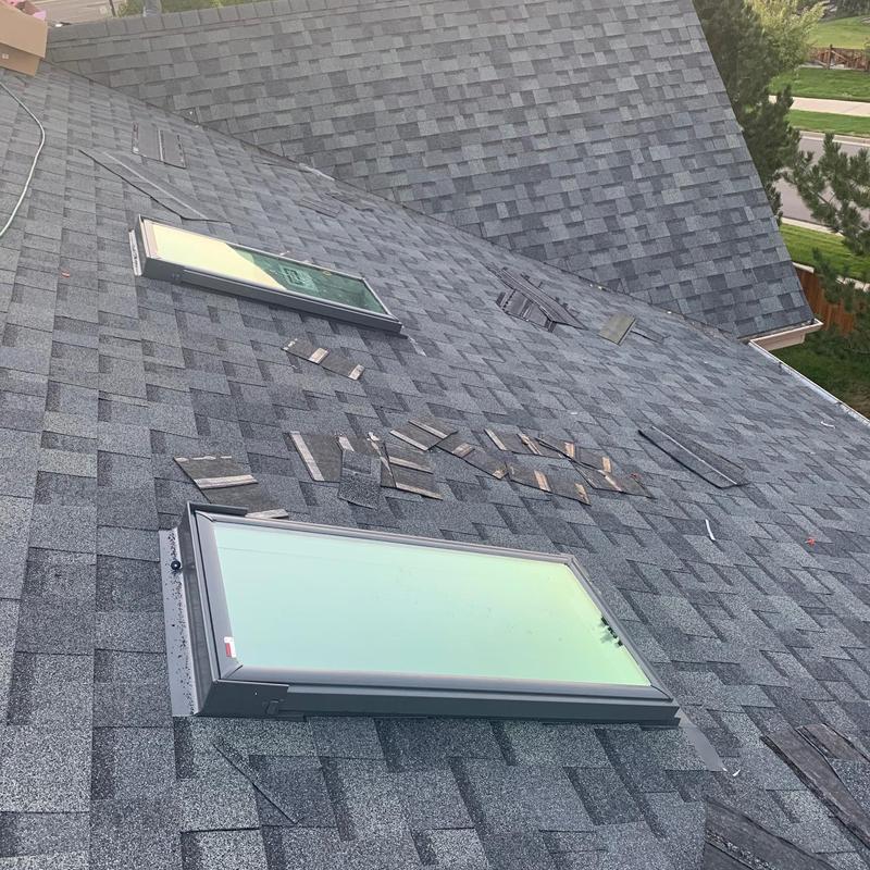 Asphalt shingle roof with hail damage near skylights