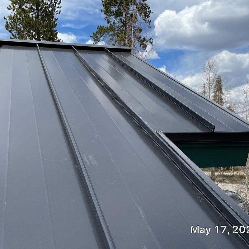 Standing seam metal roof panels with skylight flashing