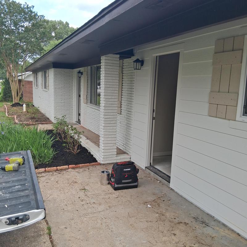 Exterior lighting and wooden shutters installation on brick wall