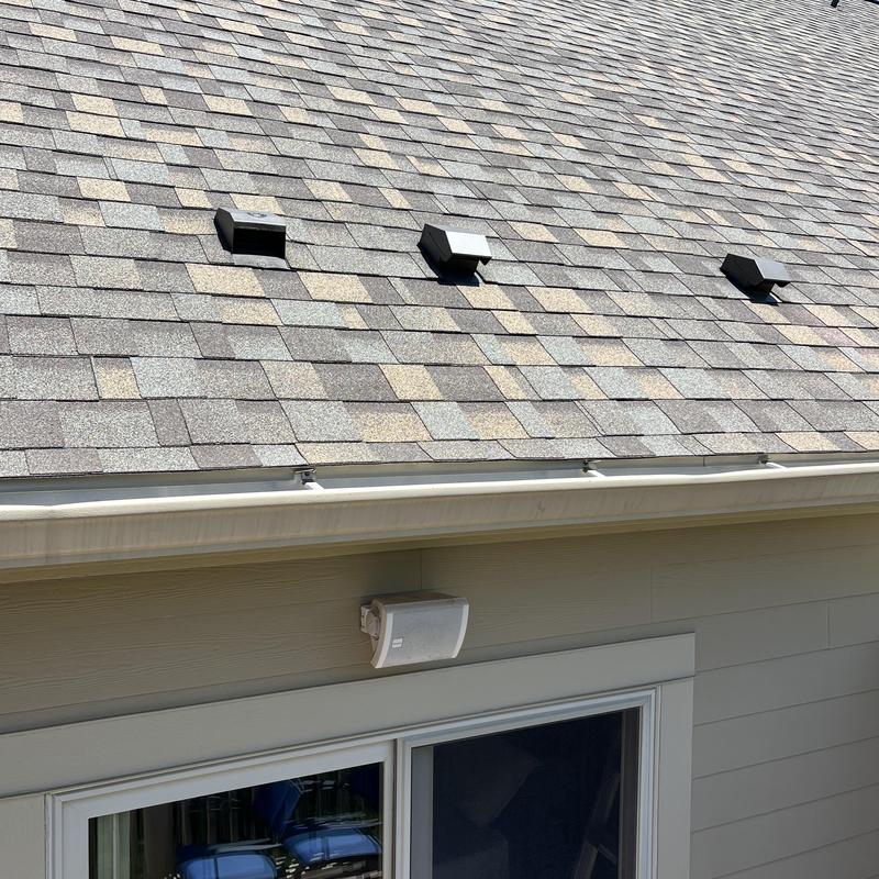 Roof shingles and gutters with vent inspection above patio door