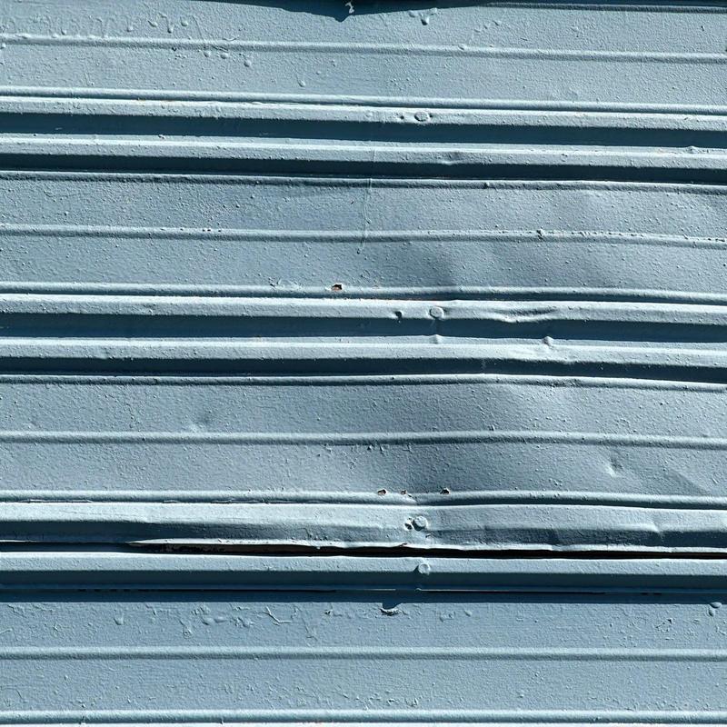 Metal roofing panel with hail damage and dents