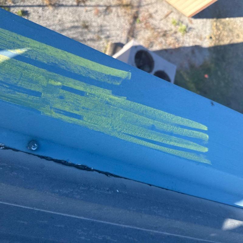 Metal flashing with hail damage markings on roof edge