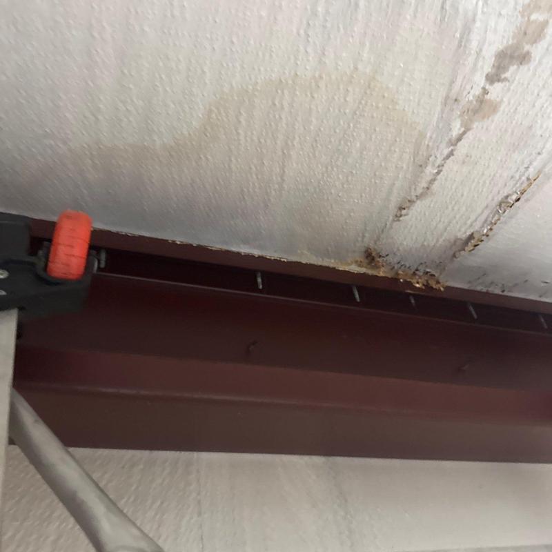 Steel roof beam with water damage and rust stains