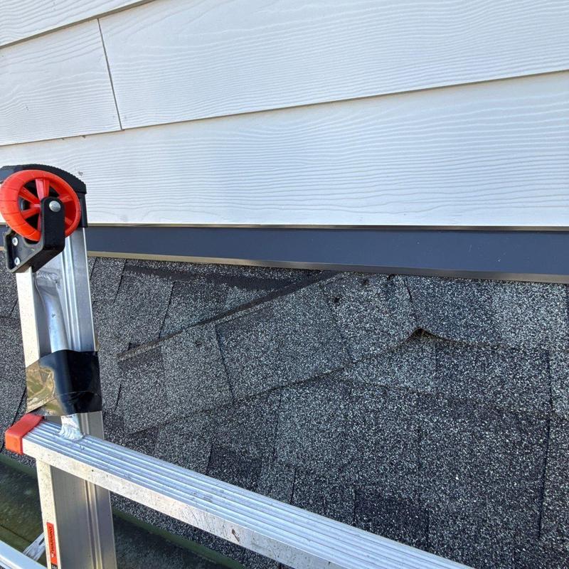 Asphalt shingle roof with hail damage near siding flashings