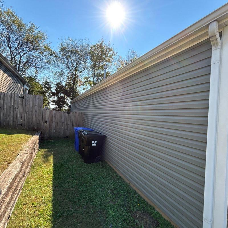 Vinyl siding and gutter downspout next to fenced yard