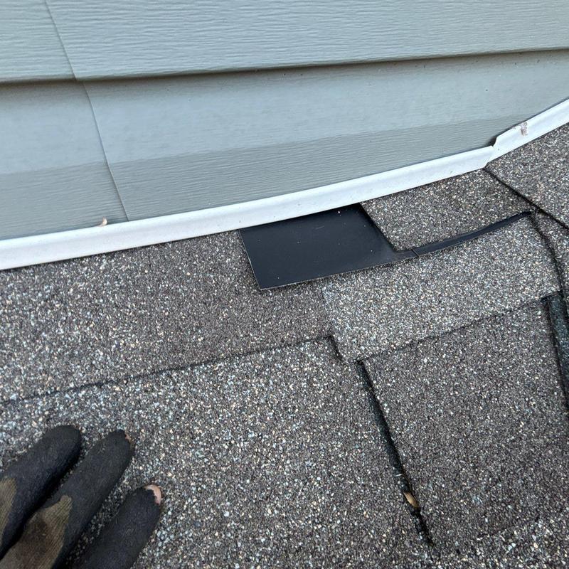 Roof shingles showing granule loss near flashing edge