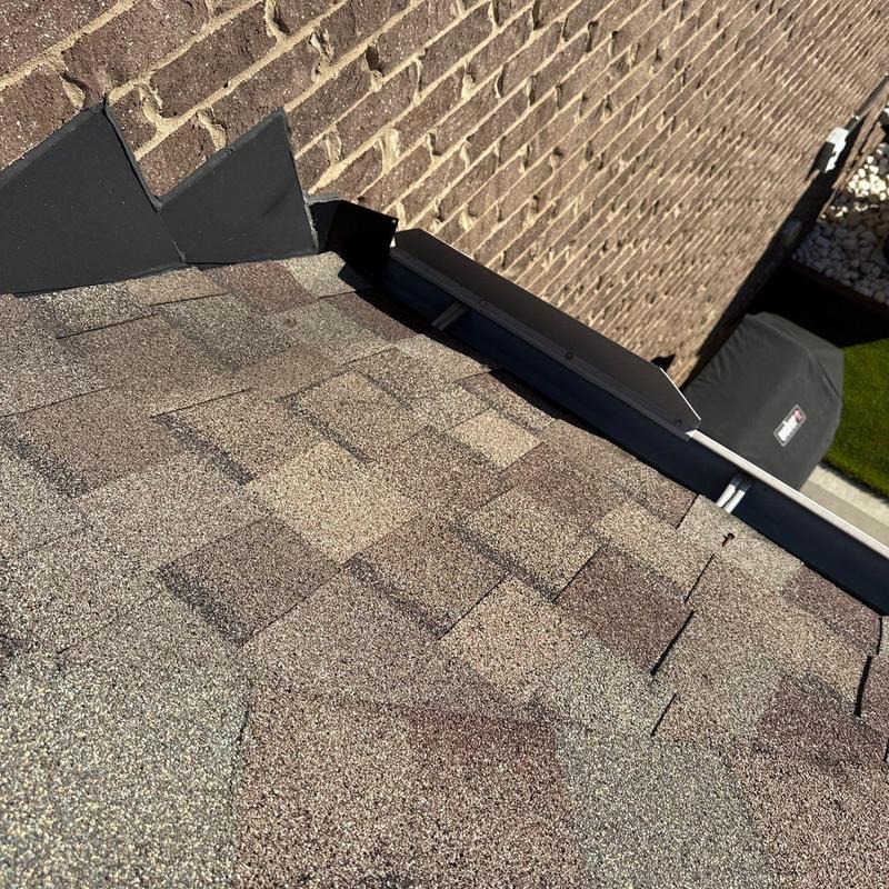 Asphalt shingles with hail damage near flashing transition