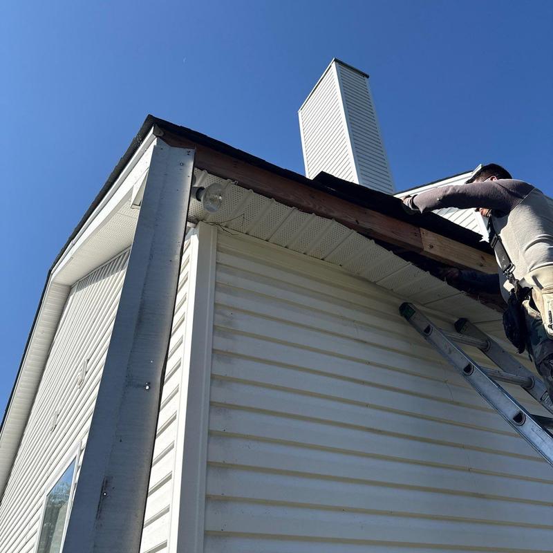 Ridge vent and roof edge inspection on ladder