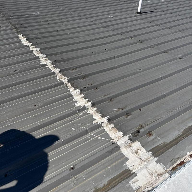 Metal roof panels with hail damage and seam sealing
