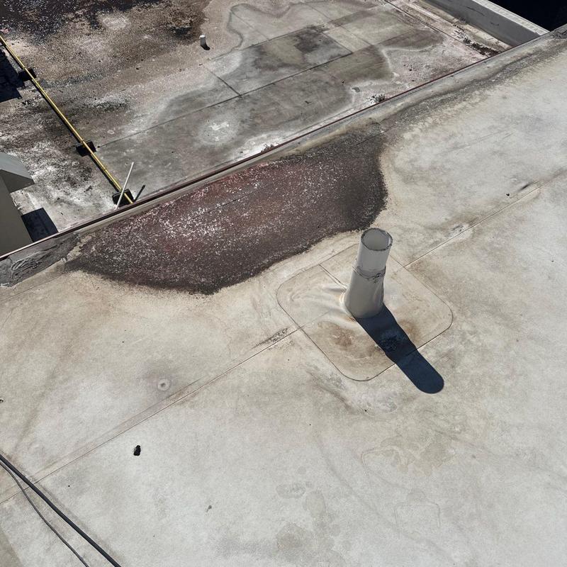 Commercial roof membrane with hail damage and flashing pipe