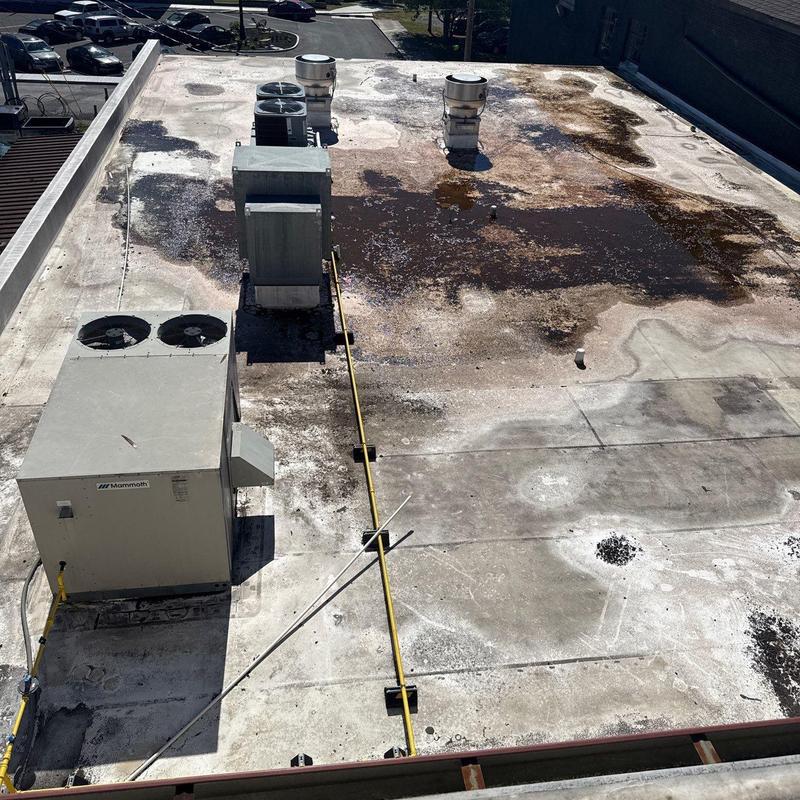 Flat commercial roof with hail damage and HVAC units