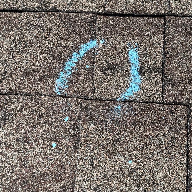 Roof shingle hail damage marked for inspection