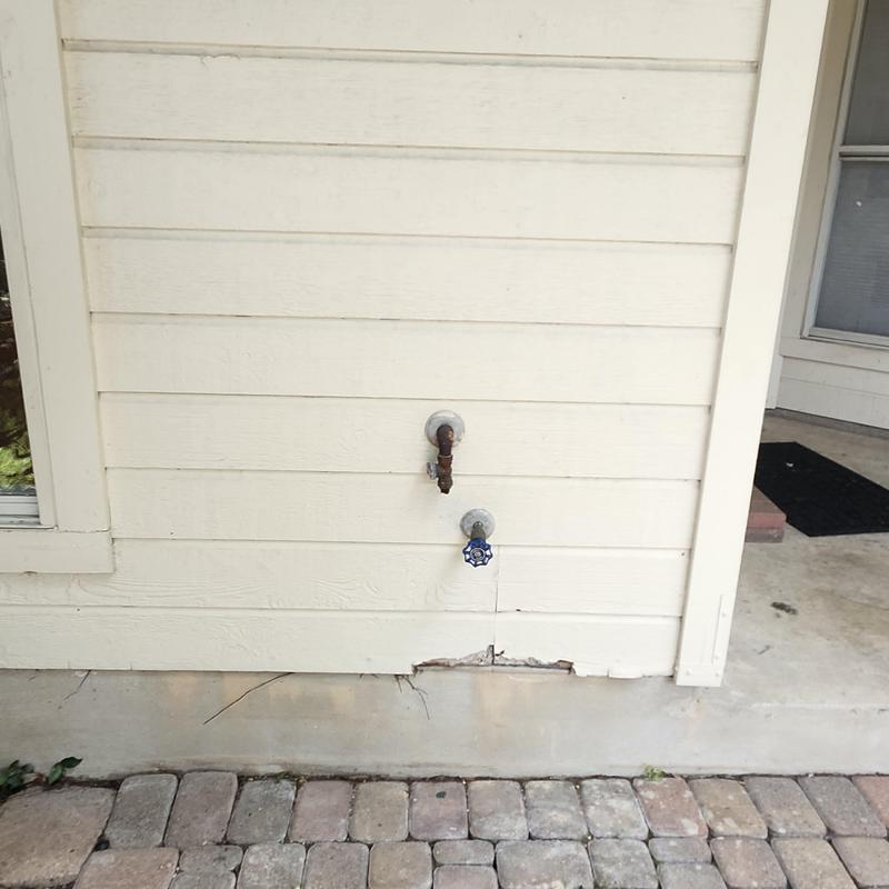 Exterior water spigots with damaged siding below