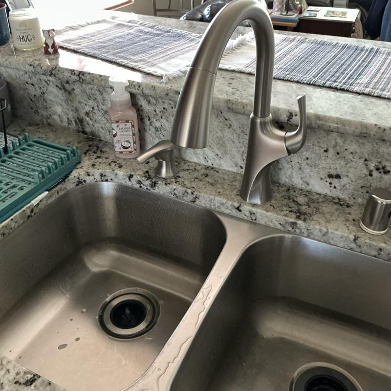 Kitchen faucet with soap dispenser on granite countertop