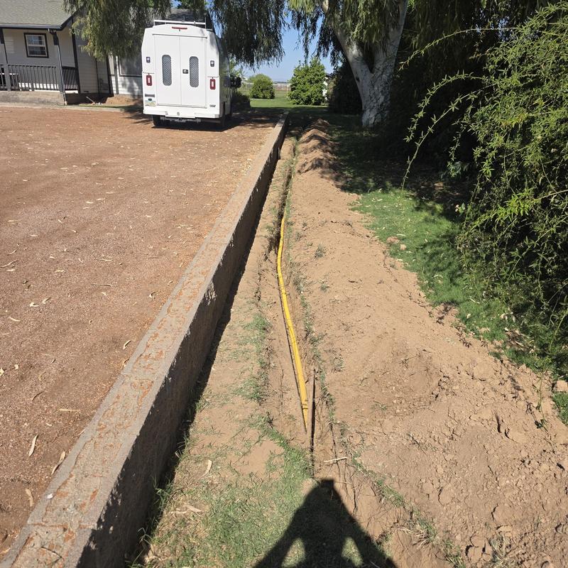 Polyethylene gas line trench running beside wall