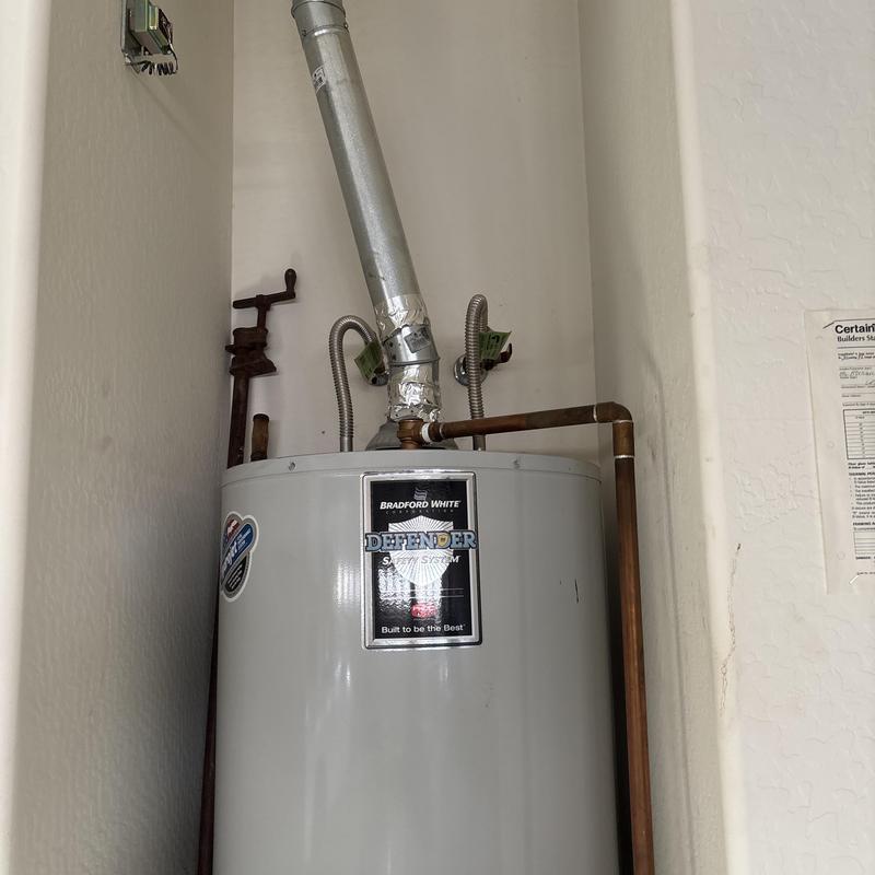 Water heater with vent pipe and copper piping in corner Water heater with vent pipe and copper piping in corner