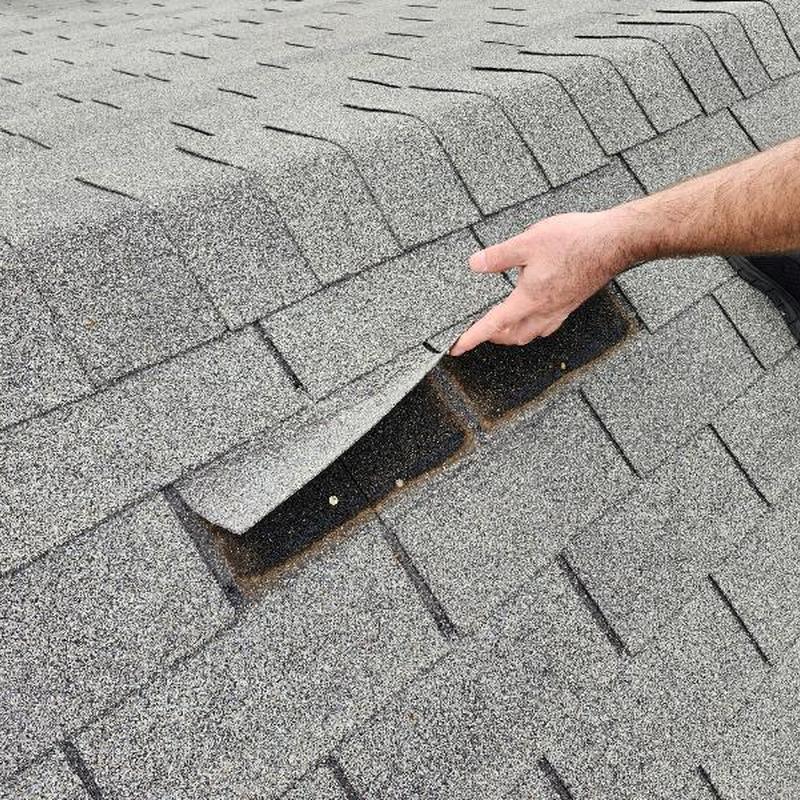 Roof shingles with one lifted exposing underlayer