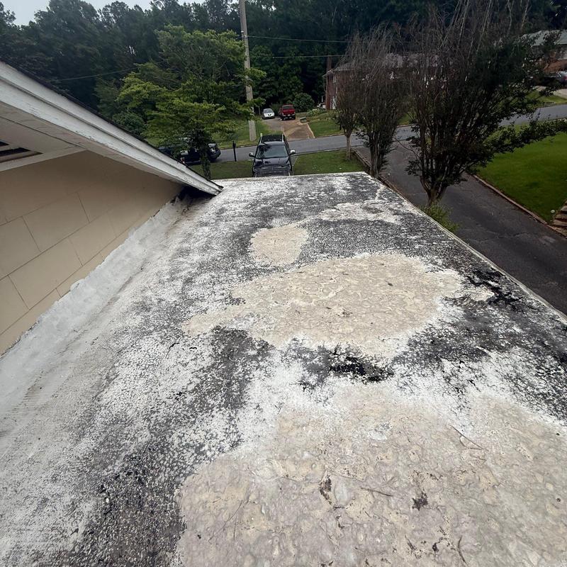 Flat roof surface with coating wear and damage