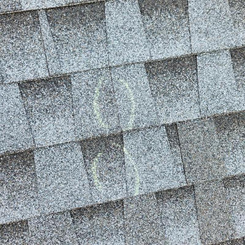 Asphalt roof shingles with marked damage spots