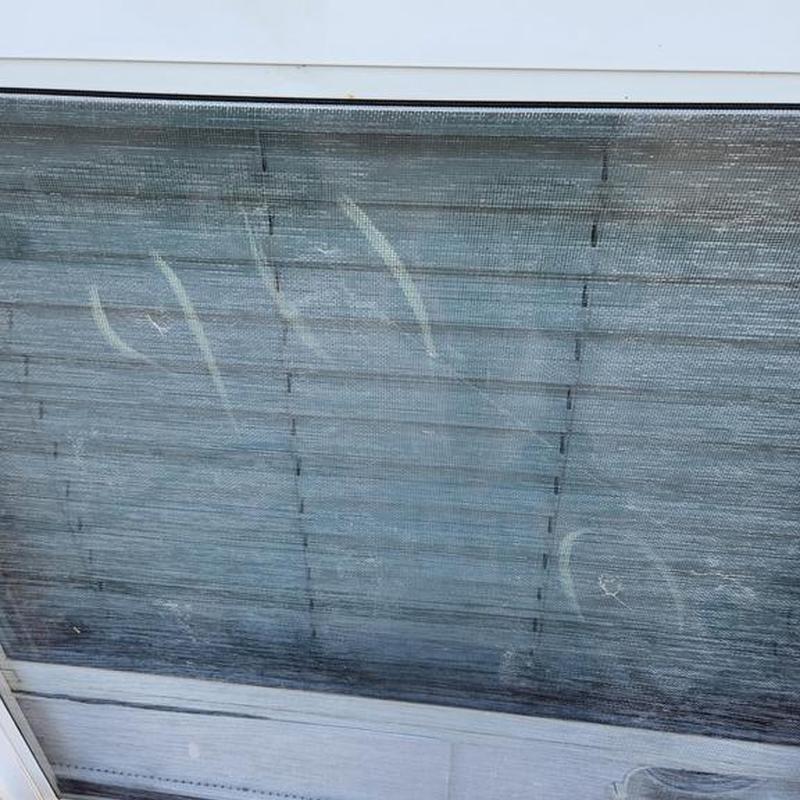 Window screen with hail damage marks in Burleson TX