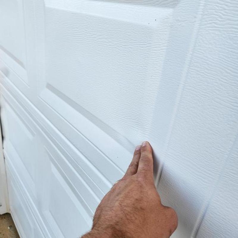 Garage door hail damage inspection with hand touch