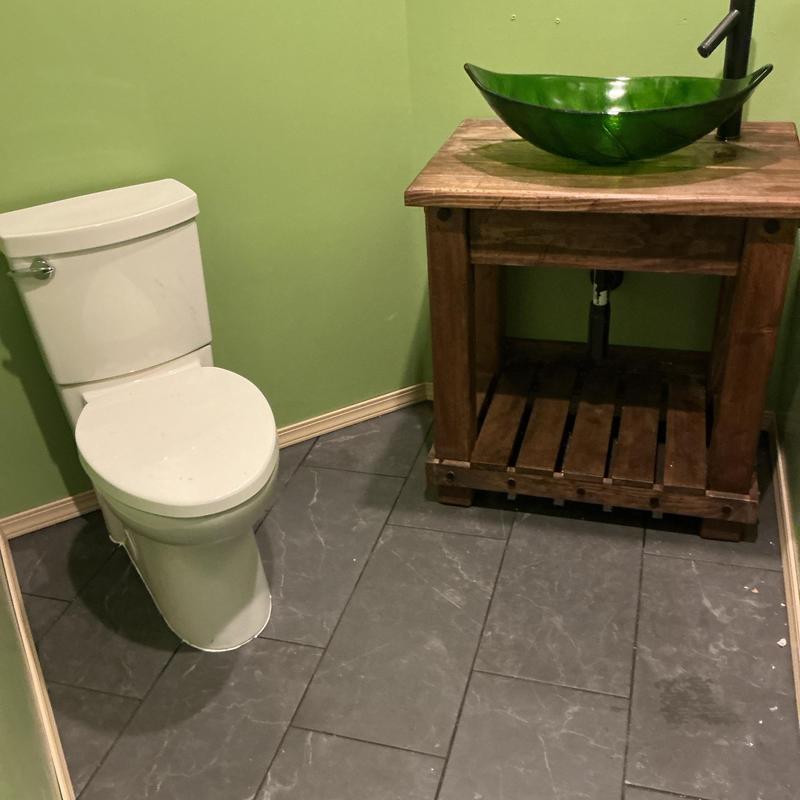 Toilet and vessel sink basin installation in bathroom
