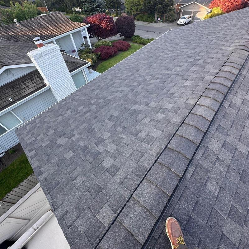 Shingle roof with ridge caps and chimney nearby