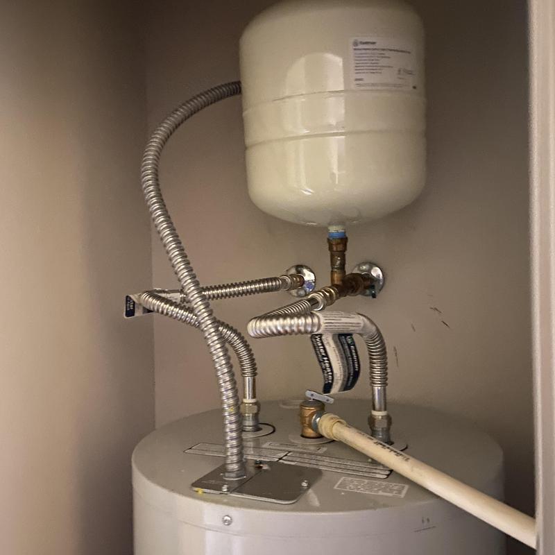 Water heater with expansion tank and flexible piping