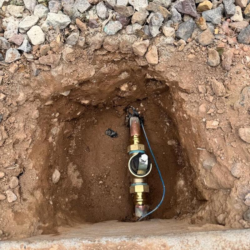 Water main valve and copper pipe installation in dirt hole