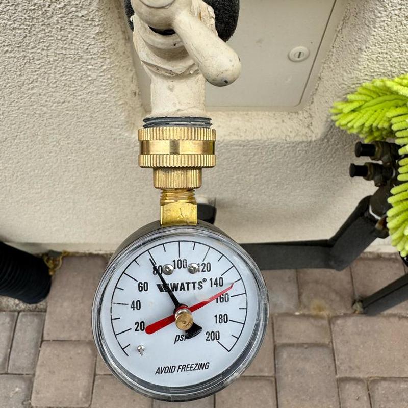 Water pressure gauge showing 80 psi on outdoor valve