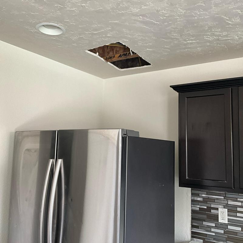 Ceiling leak damage above kitchen refrigerator and cabinet