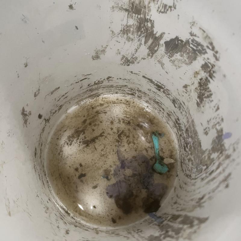 Garbage disposal debris and plastic spoon inside housing