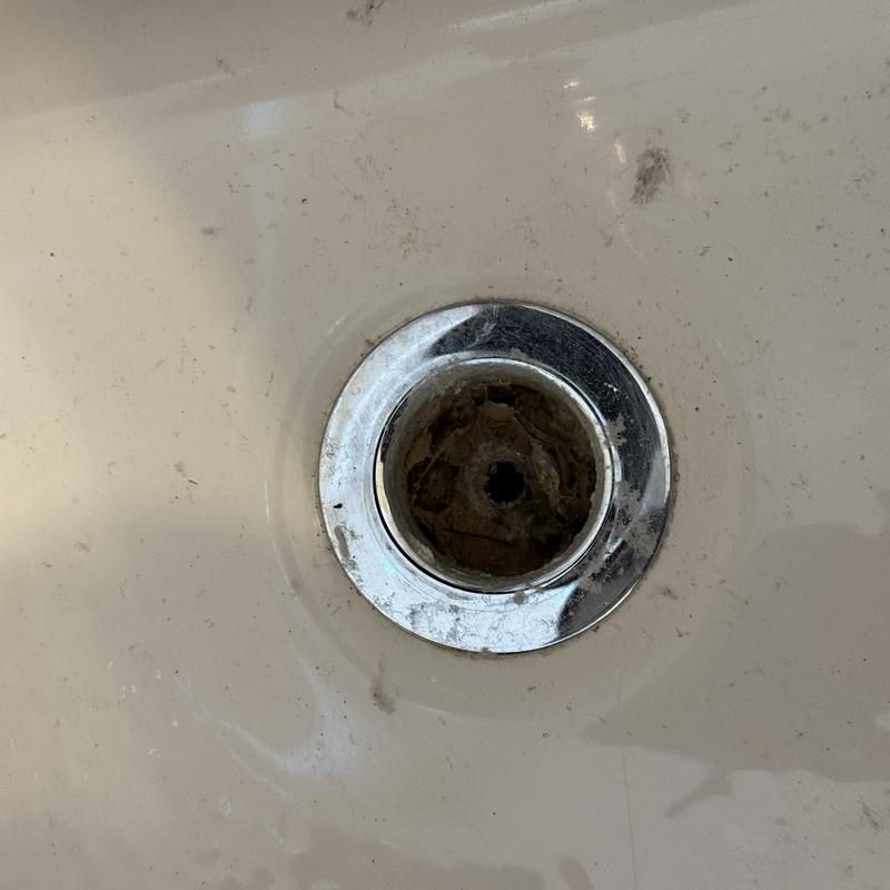 Tub drain with clog and dirt buildup inside Tub drain with clog and dirt buildup inside