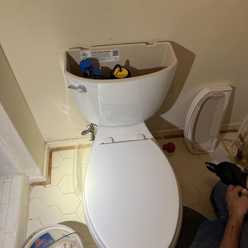 Kohler toilet tank with removed lid in bathroom Kohler toilet tank with removed lid in bathroom