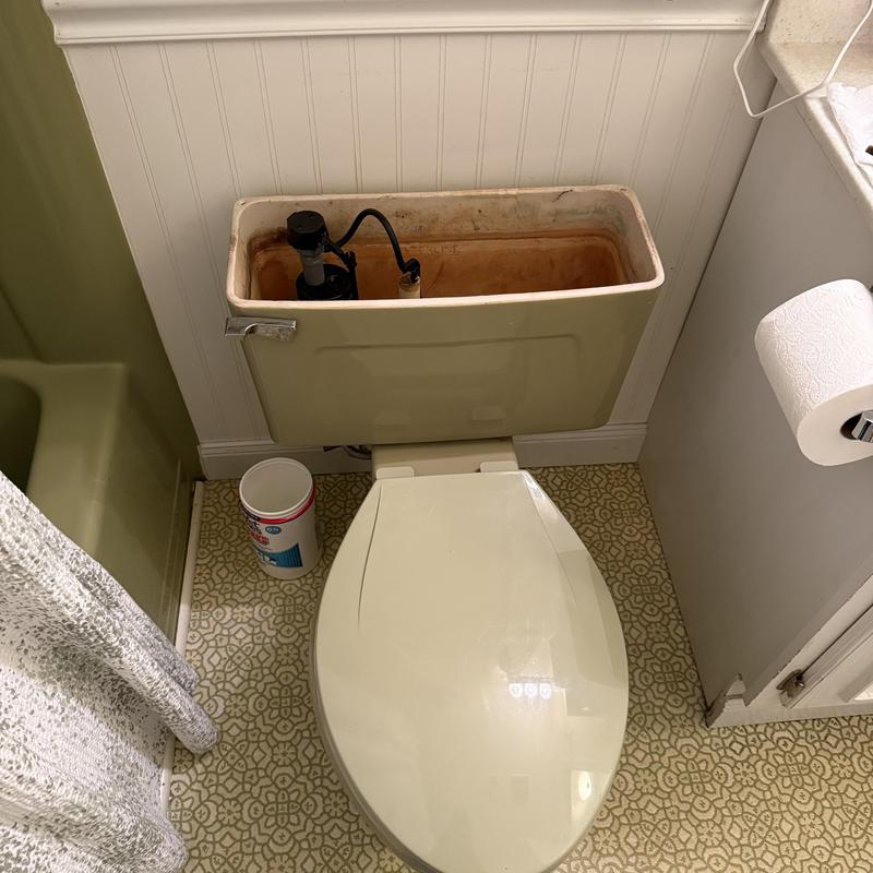 Toilet tank with internal plumbing components exposed Toilet tank with internal plumbing components exposed