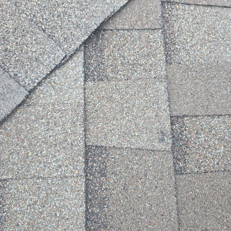 Asphalt shingles with hail impact marks close-up Asphalt shingles with hail impact marks close-up