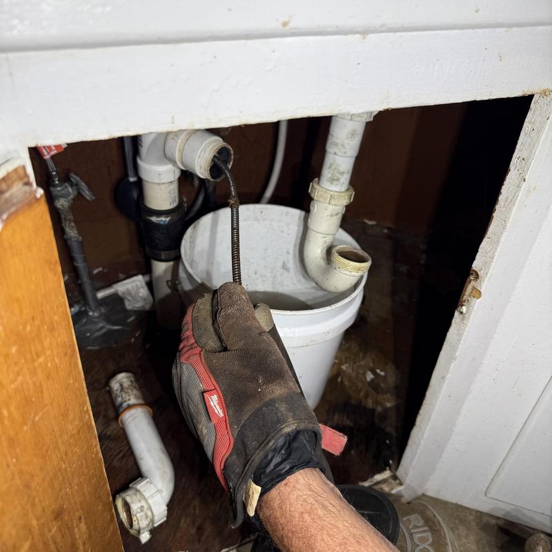 Kitchen sink drain pipe unclogging with drain snake tool Kitchen sink drain pipe unclogging with drain snake tool