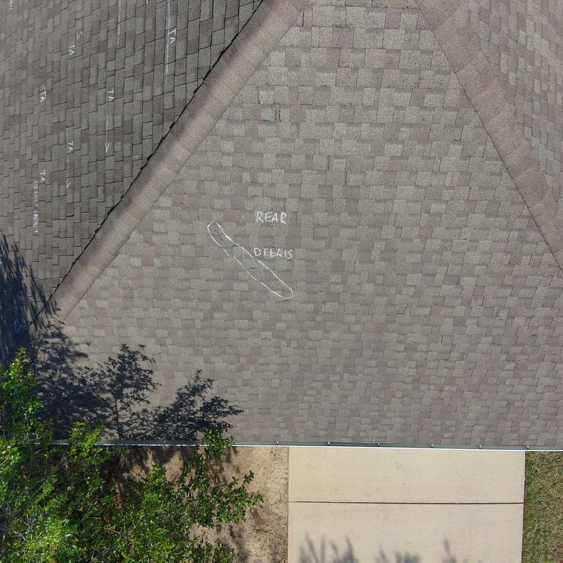 Asphalt roofing shingles with debris impact damage marked Asphalt roofing shingles with debris impact damage marked