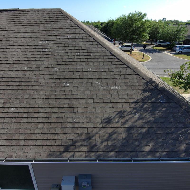 Asphalt shingles with wind damage markings on roof Asphalt shingles with wind damage markings on roof