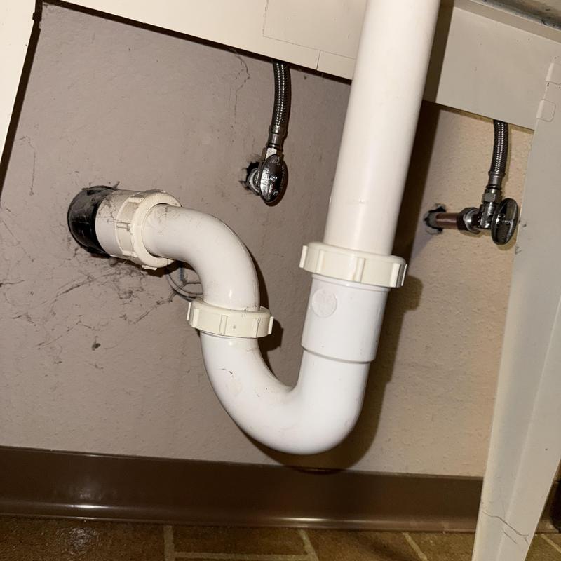 Bathroom sink drain pipe and angle stop valves under cabinet