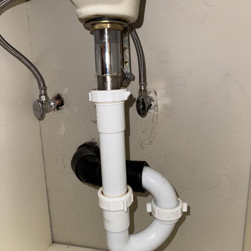 PVC drain trap and supply valve connections under sink