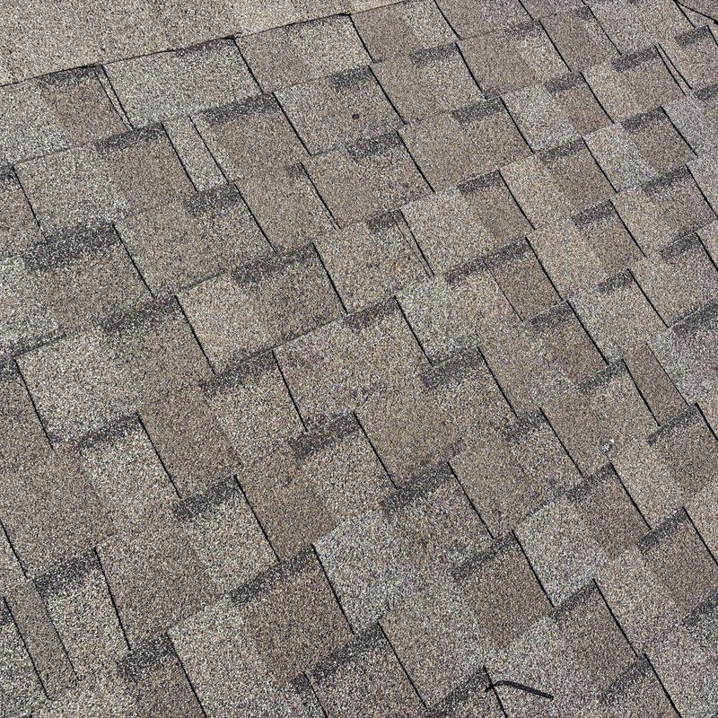 Asphalt shingles with hail impact damage close-up