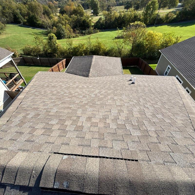 Asphalt shingle roof with visible hail damage and ridge gaps