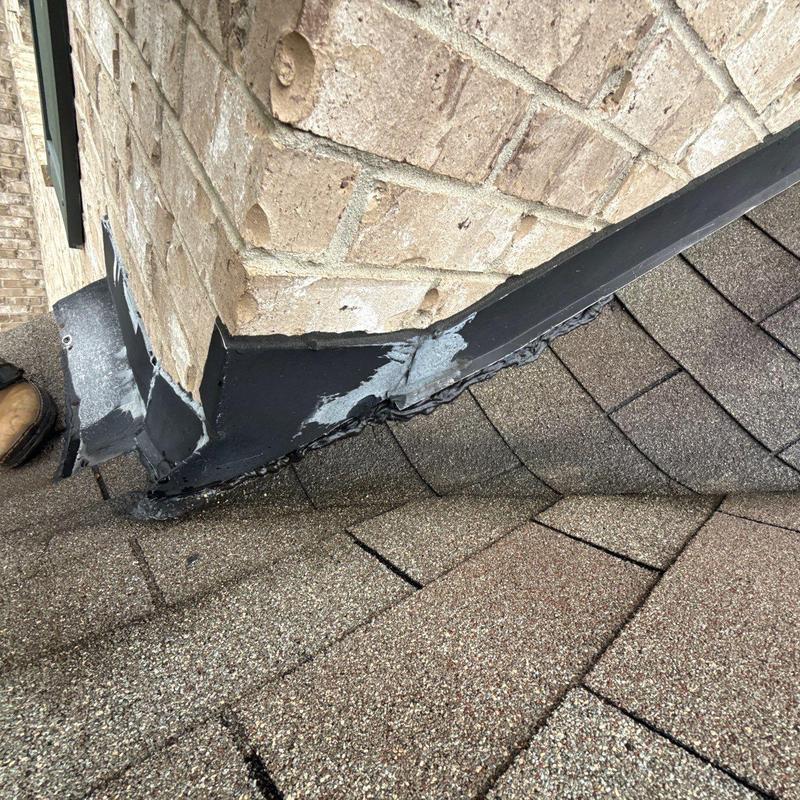 Roof flashing with sealant damage on shingle roof corner