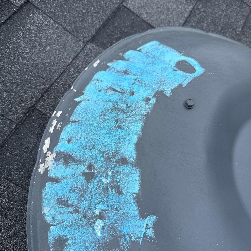 Satellite dish with blue paint damage on roof shingles
