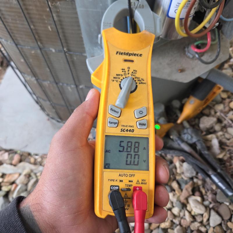 Clamp meter measuring AC current on air conditioner unit Clamp meter measuring AC current on air conditioner unit