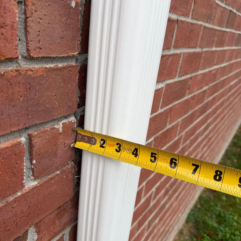 Downspout diameter measurement against brick wall