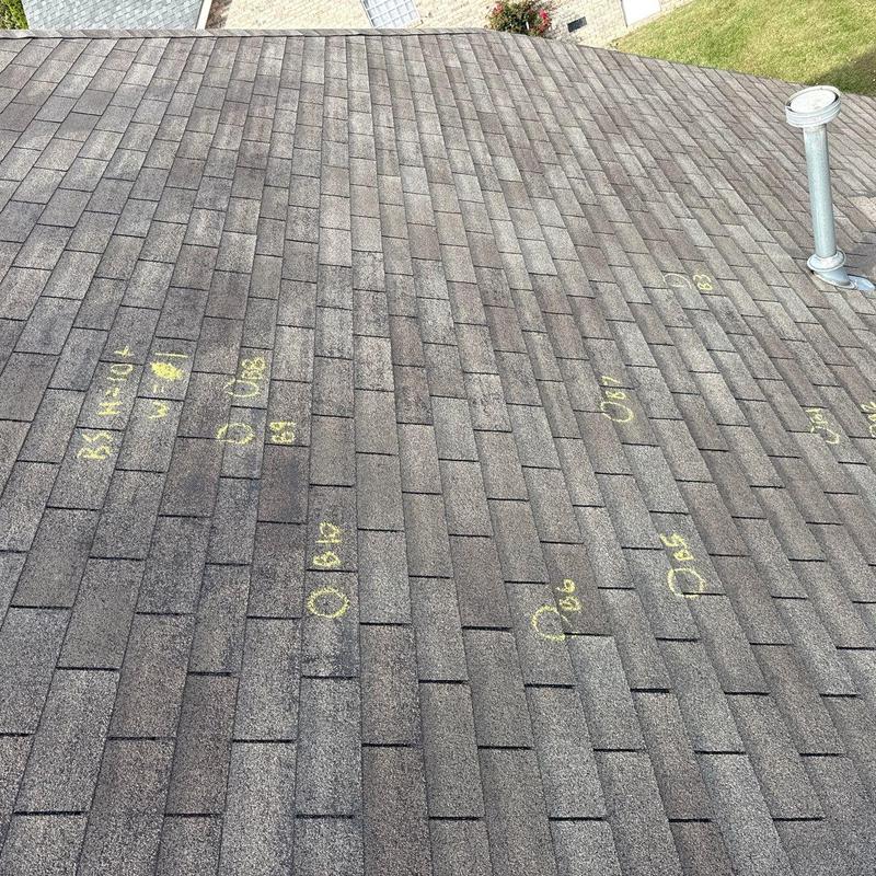 Roof shingles with hail damage markings and vent pipe